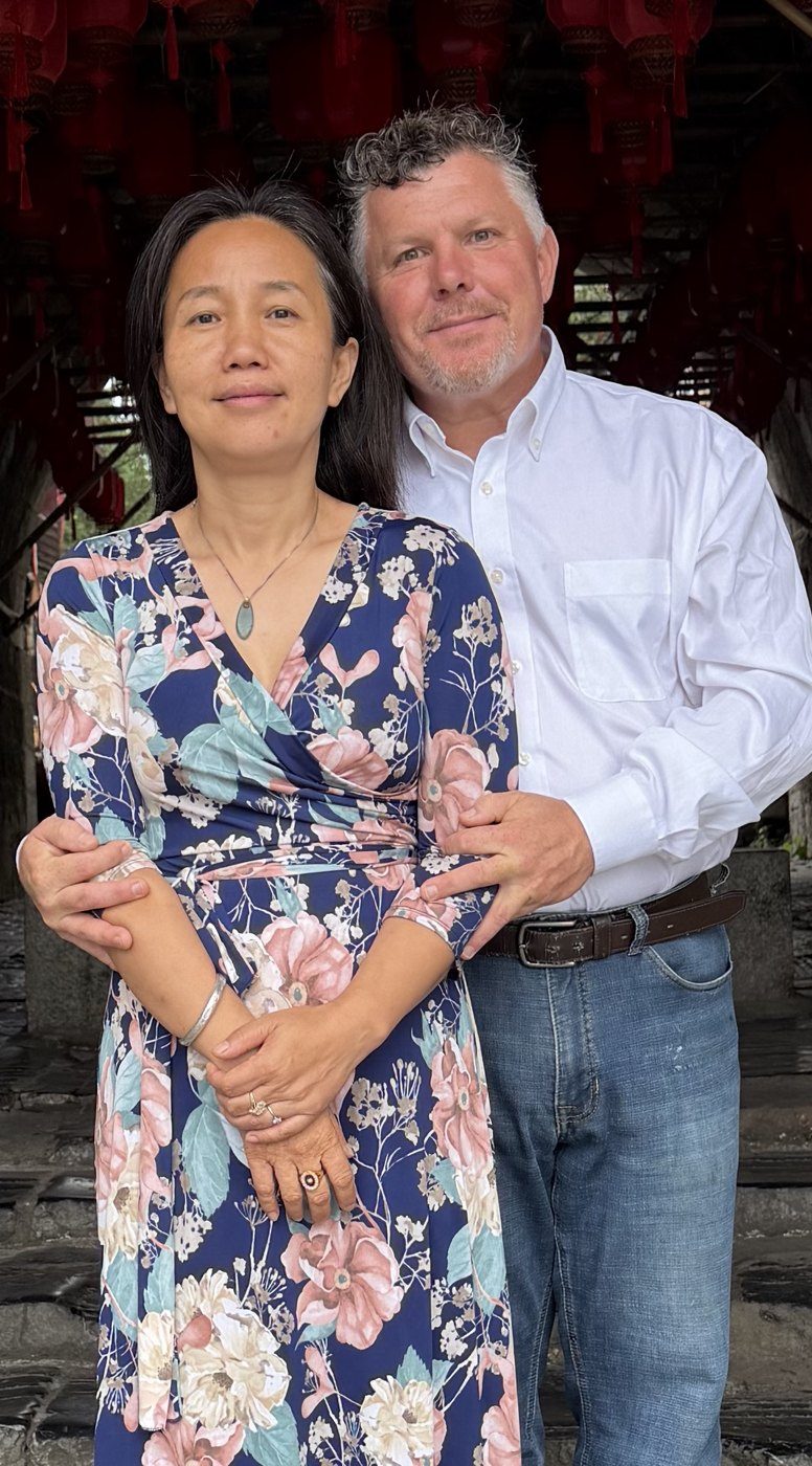 Joshua and Fengyi standing together under red lanterns